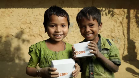 Children holding CARE boxes