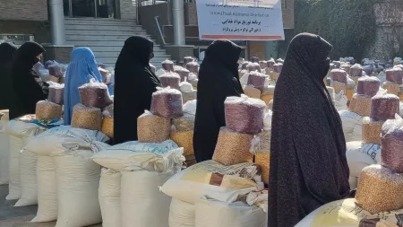 Women standing next to food packages in Afghanistan