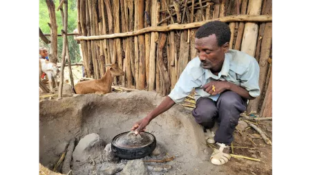 Ethiopia_Man kneeling next to cooking pit