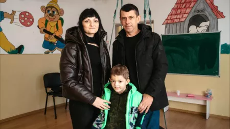 Ukraine-Romania_Parents standing with little boy in kindergarten