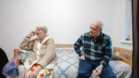 Elderly couple sitting on a bed