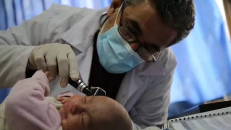 Male doctor examining baby