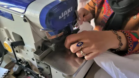 Afghanistan_Woman's hands holding fabric in sewing machine