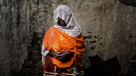 Nigeria_Woman in orange shawl and white scarf disguising her face