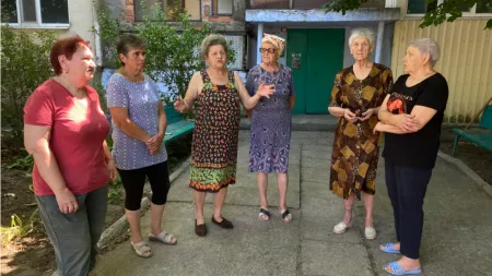 Ukraine_Old women standing in half circle discussing outside