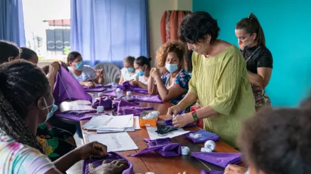 Ecuador_Women sitting around a table sewing purple cloths
