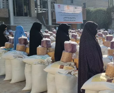 Women standing next to food packages in Afghanistan