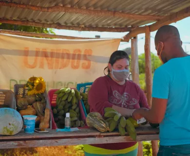 Cuba_Road side vendor selling bananas to man in blue shirt