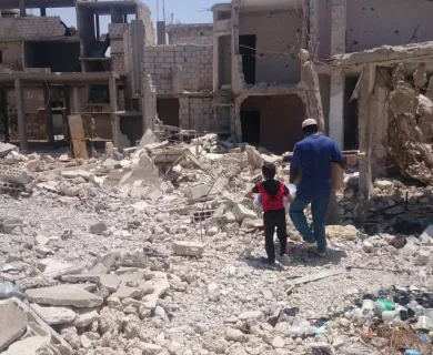 Syria_Man and boy walking in rubble