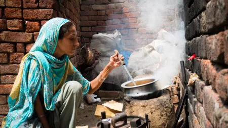 Woman cooking in brick house