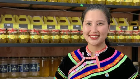 Luu Thi Hoa in front of honey shelf in Vietnam
