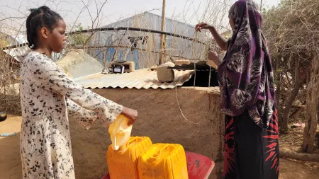 Asha Mohammed, 43, fetches water from her neighbors.