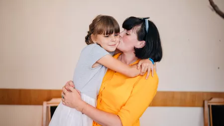 Iryna, 31, volunteer, in Lutsk holding her daughter Victoria, 8.