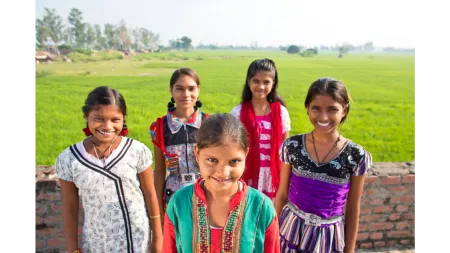 Indian girls in front of field of grass