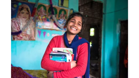Nepalese young girl smiling holding books