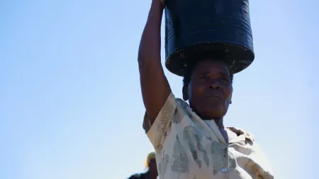 Woman carrying galon of water over her head