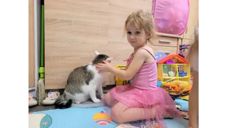 Ukraine_Little girl playing with cat