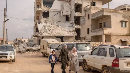 Woman and girls walk past a destroyed building follwing the Earthquake in Idlib, Syria