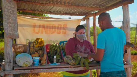 Cuba_Road side vendor selling bananas to man in blue shirt