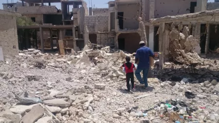 Syria_Man and boy walking in rubble