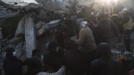 Syrian emergency workers and civilians moving rubble