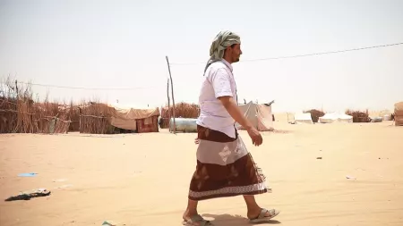 Yemen_Man with cloth around his waist and head scarf walking through desertous land