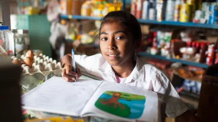 Timor-Leste_Girl sitting in small shop doing homework