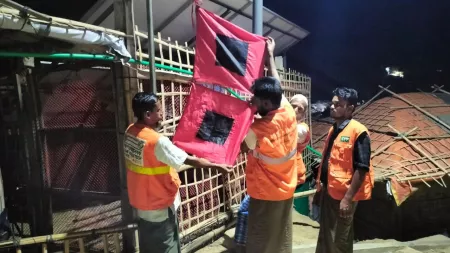 Men putting up red and black disaster warning flag