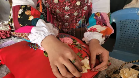 Afghanistan_Woman hand sewing pillow