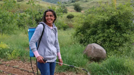 Lebanon_Woman holding pesticide hose in small garden