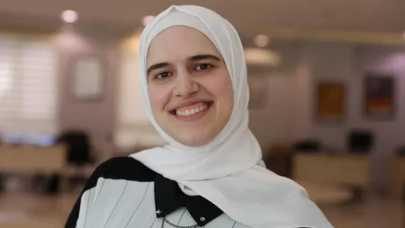 Turkiye_Woman in stripped shirt and white hijab smiling at camera
