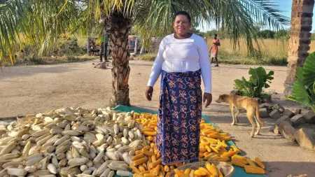 Zambia_Lady standing among corn cobs on the floor