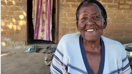 Zambia_Older lady smiling wearing blue and white shirt