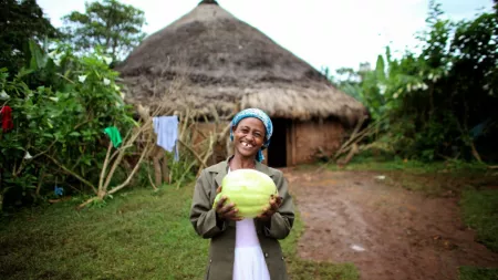 Ethiopia_Woman with gap in teeth holding a melon smiling