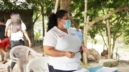 Honduras_Erika standing behind registration desk in white shirt