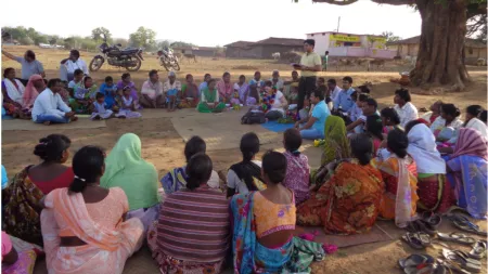 India_Community members sitting in big circle listening to another member speaking