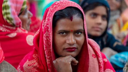 India_Woman with red bindi and red sari looking into camera smirking