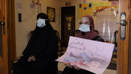 Syria_Two women with niqab and masks and one holding a drawing of earthquake