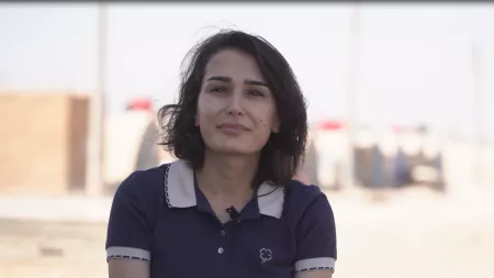 Syria_Woman in blue shirt smiling at camera