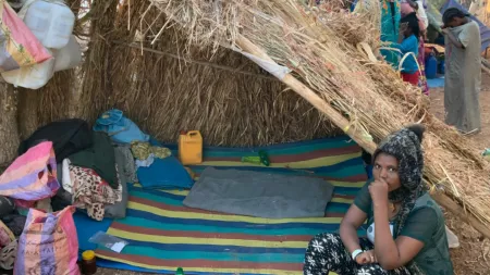Tigray_Woman sitting in front of tent made of dry straw on the floor