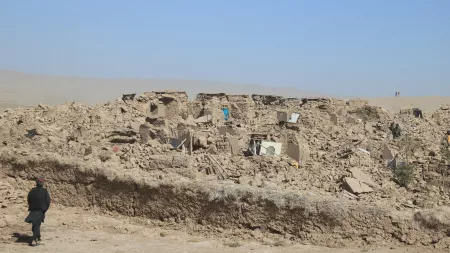 person passing by rubble