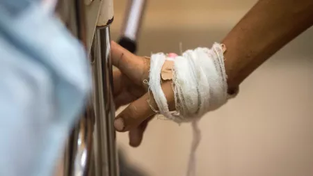 Hand with bandage holding gurney