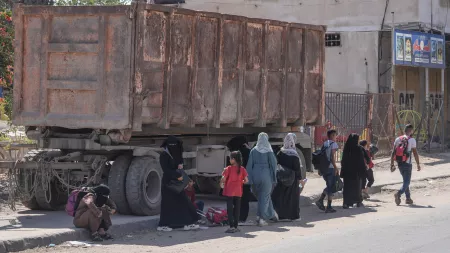 People walking in front of truck in Gaza