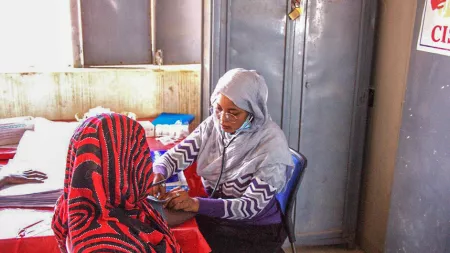 Woman healthcare worker provides care to another woman
