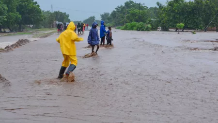 People wearing rain coats in flooded street