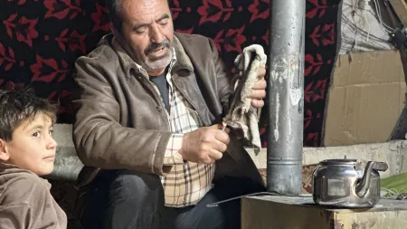 Man preparing tool to cook with child by his side