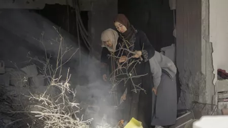 women looking down amid rubble