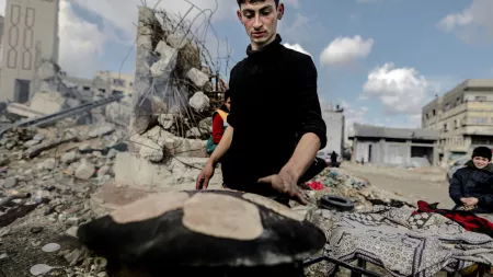 A Palestinian man is baking bread over a wood fire due to the lack of cooking gas and electricity in Jabalia refugee camp, located in the besieged area of Northern Gaza.