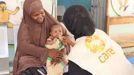 A CARE Somalia health worker checks on a child at a health facility. 