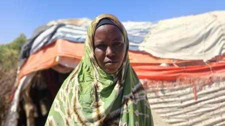 Farah, an internally displaced mother, stands in front of her tent in Somaliland.